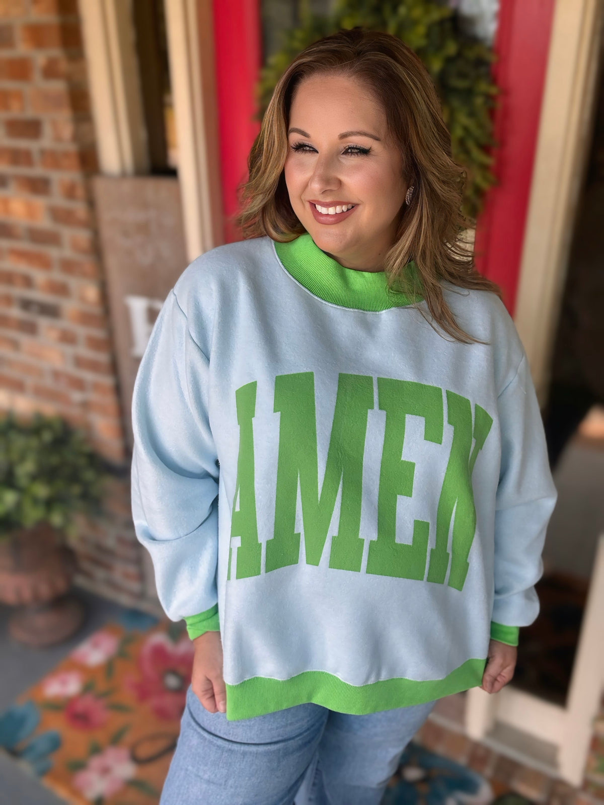 Reversible light blue and green Amen mock neck sweatshirt shown with green lettering on one side and a houndstooth print on the reverse.