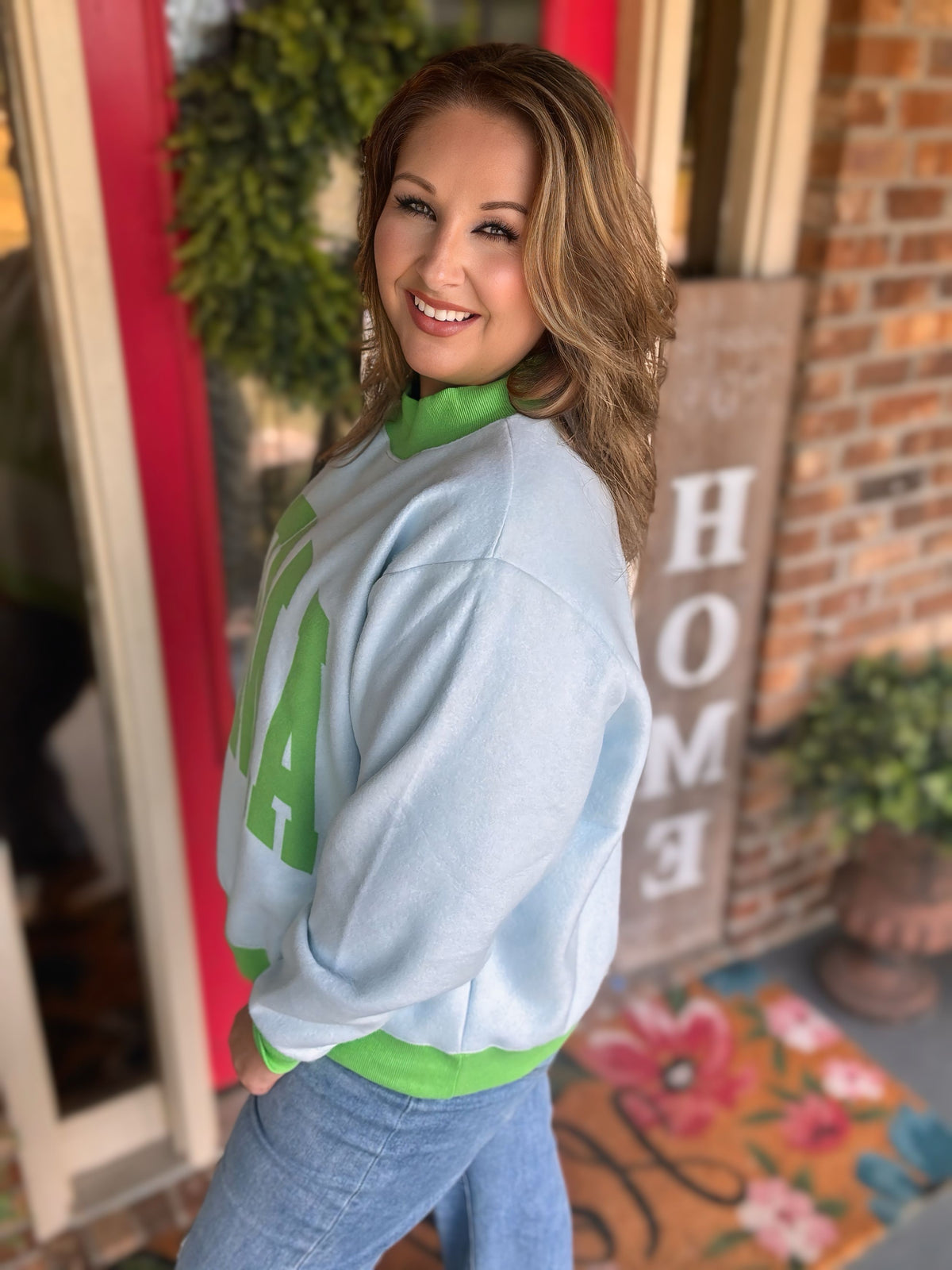 Reversible light blue and green Amen mock neck sweatshirt shown with green lettering on one side and a houndstooth print on the reverse.
