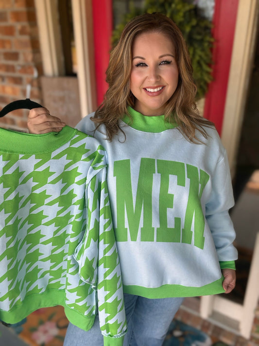 Reversible light blue and green Amen mock neck sweatshirt shown with green lettering on one side and a houndstooth print on the reverse.