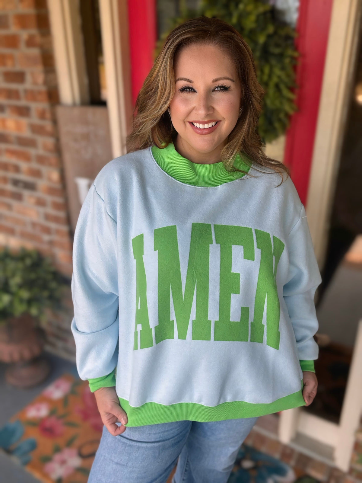 Reversible light blue and green Amen mock neck sweatshirt shown with green lettering on one side and a houndstooth print on the reverse.